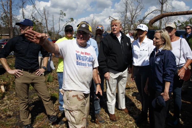 President Trump and Melania Trump tour a neighborhood affected by Hurricane Michael on Monday in Lynn Haven, Florida. Homeland Security Secretary Kirstjen Nielsen is front right.  (AP Photo/)
