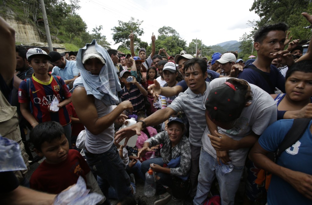 Honduran migrants receive water from Guatemalan police at the Honduran border crossing Monday. An estimated 1,600 migrants traveling together eventually crossed into Guatemala as they head for the United States.