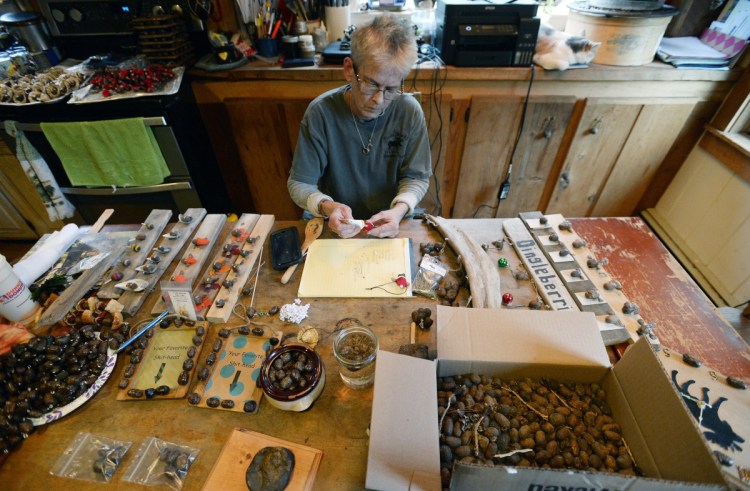 Mary Winchenbach makes moose turd art in her kitchen. She recently quit her job to keep up with orders. "When you put them eyeballs on them turds, they get their own little personalities, God bless them," she said.