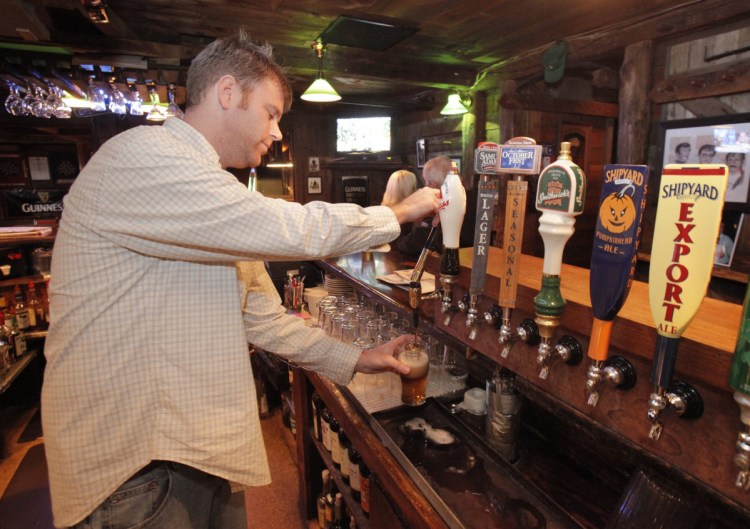 In this 2010 file photo, Ryan Kerry pours a black & tan at the Kerrymen Pub in Saco.