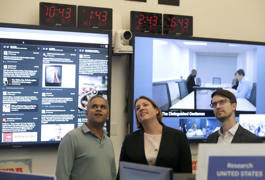 Samidh Chakrabarti, Director of Elections and Civic Engagement, from left, stands with Katie Harbath, Global Politics and Government Outreach Director and Nathaniel Gleicher, Head of Cybersecurity Policy, during a demonstration in the war room, where Facebook monitors election related content on the platform, in Menlo Park, Calif., Wednesday, Oct. 17, 2018.