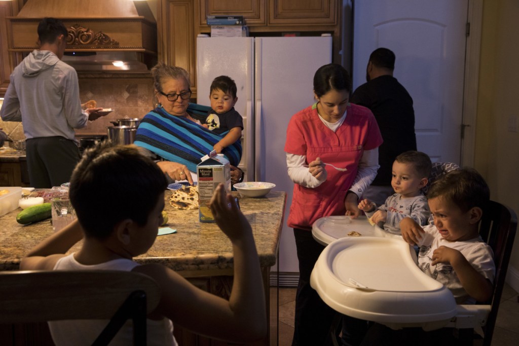 In this Thursday, Sept. 6, 2018, photo, Lilia Coyt, center left, and Coyt's daughter-in-law, Araceli Nunez, feed babies in their four-bedroom home, where three generations and 15 members of the family are jammed into, in Salinas, Calif. Few cities exemplify California's housing crisis better than Salinas, an hour's drive from Silicon Valley and surrounded by farm fields. It's one of America's most unaffordable places to live, and many residents believe politicians lack a grip on the reality of the region's housing crisis.