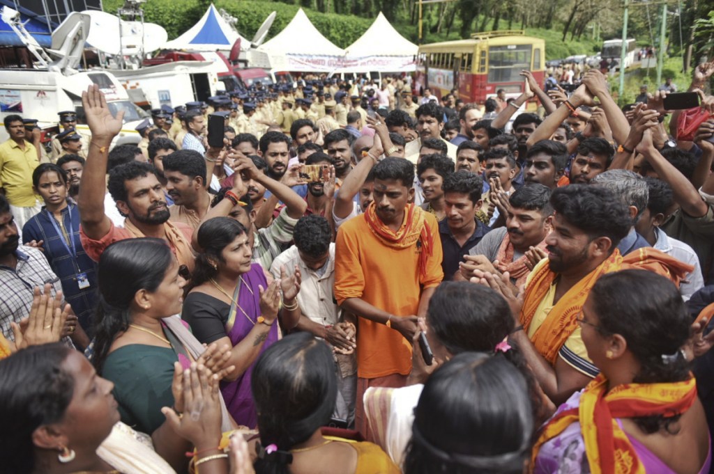 Protesters who are opposed to allowing women of menstruating age from entering the Sabarimala temple chant devotional hymns as they gather at Nilackal, a base camp on way to the mountain shrine in Kerala, India, Wednesday. The historic mountain shrine, one of the largest Hindu pilgrimage centers in the world is set to open its doors to females of menstruating age following a ruling by the country's top court. Police arrested some protesters when they tried to block the path of some females. (AP Photo)
