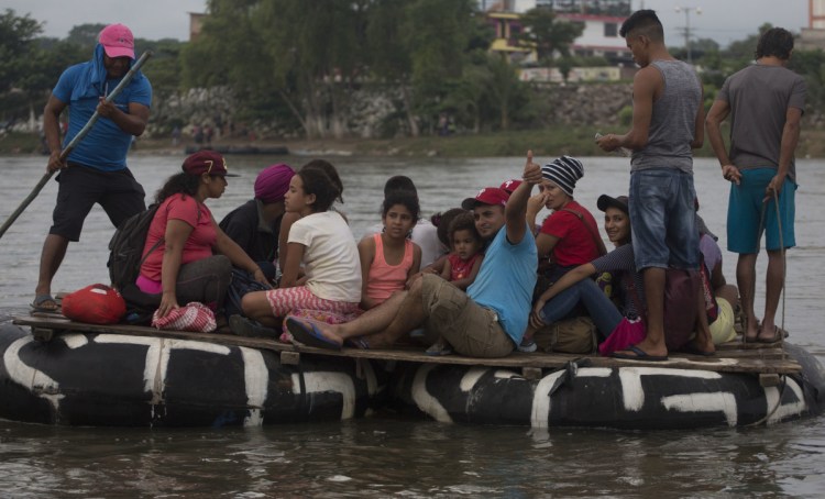 Honduran migrants cross the Suchiate River aboard a raft made out of tractor inner tubes and wooden planks, in Tecun Uman, Guatemala, on Saturday.