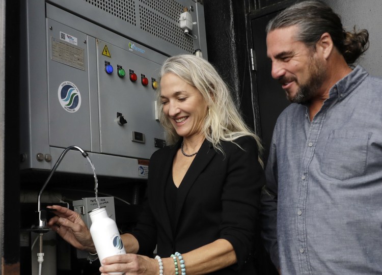 Skysource/Skywater Alliance co-founders David Hertz, right, and his wife, Laura Doss-Hertz, demonstrate the Skywater 300, a machine that makes water from air, in Los Angeles this week.