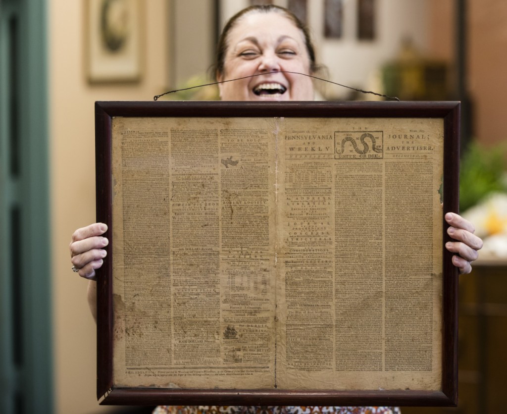 Heather Randall displays a Dec. 28, 1774 Pennsylvania Journal and the Weekly Advertiser at Goodwill Industries South Jersey in Bellmawr, N.J., Thursday.
At left, two of the advertisements on the front page.