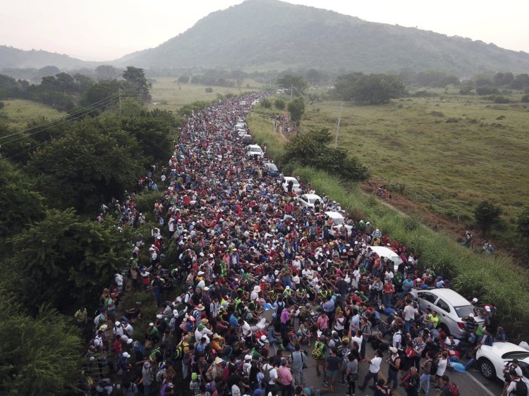 Members of a U.S.-bound migrant caravan stand on a road after federal police briefly blocked their way outside the town of Arriaga on Saturday. Hundreds of Mexican federal officers carrying plastic shields had blocked the caravan from advancing toward the United States, after several thousand of the migrants turned down the chance to apply for refugee status and obtain a Mexican offer of benefits. Associated Press/Rodrigo Abd