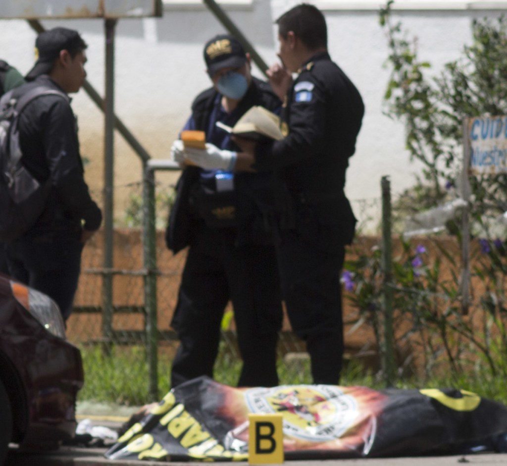 Police in Guatemala City investigate the murder of a guard outside a hospital in 2017. Violence is a prime motivator for many of the migrants heading for the U.S.
