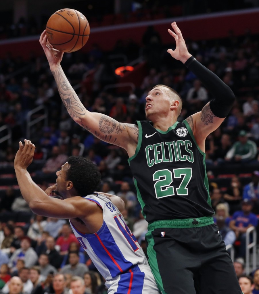 Daniel Theis of the Celtics leaps over Pistons guard Ish Smith to catch a pass Saturday during Boston's 109-89 win. Associated Press/Carlos Osorio