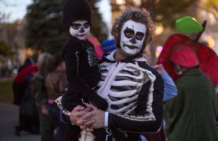 Michael Gatlin and his son Ovid, 5, await the start of the Halloween parade on Brackett Street in Portland last year.
