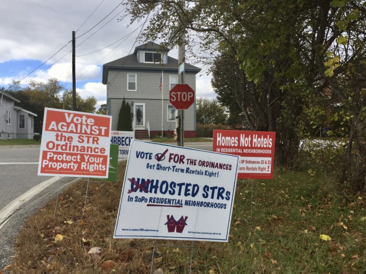 Campaign signs at Nutter Road and Evans Street in South Portland urge voters to cast their ballots either for or against controversial short-term rental regulations that the City Council approved in July.
