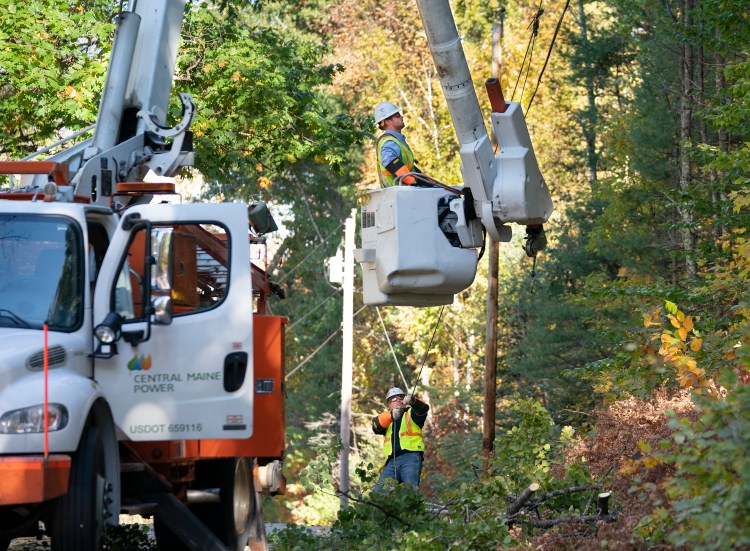 Andrew VanDecker, in bucket, and Paul Reynolds, both linemen with Central Maine Power, work on a power line that had a tree fall on it on Conesca Road in Raymond on Tuesday. 