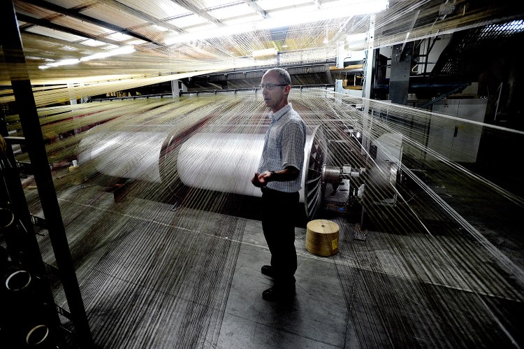 Johan Moulin, president of Flemish Master Weavers in Sanford, stands near one of the company's looms. He said the company is the only U.S. rug manufacturer that lacks its own yarn-making operation.