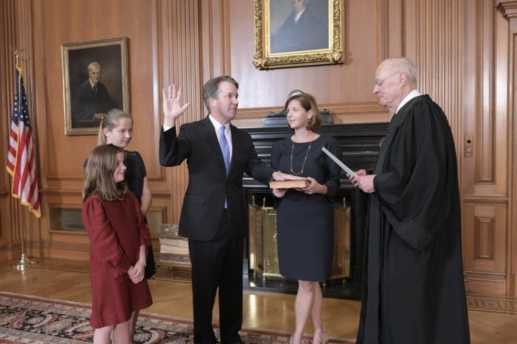 Retired Justice Anthony M. Kennedy, right, administers the Judicial Oath to Judge Brett Kavanaugh in the Justices’ Conference Room of the Supreme Court Building. Ashley Kavanaugh holds the Bible. At left are their daughters, Margaret, background, and Liza. 