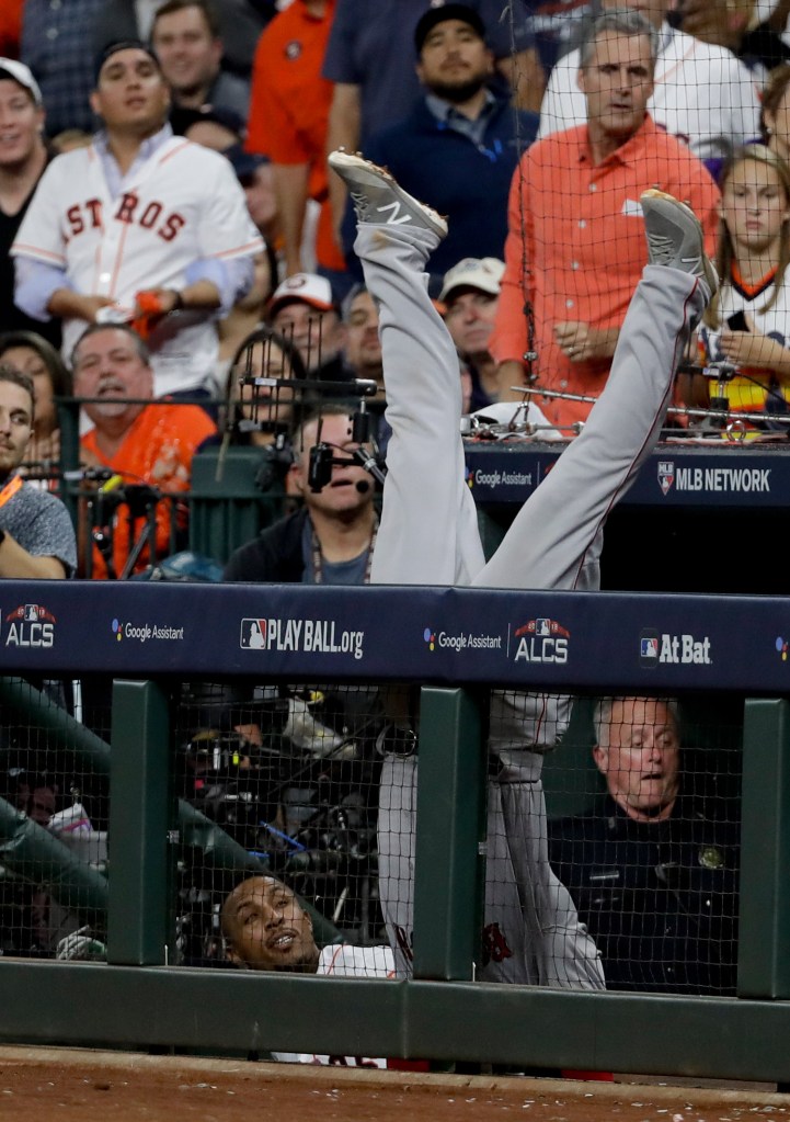 Red Sox first baseman Steve Pearce falls into the Houston dugout trying to catch a foul ball hit by the Astros' Josh Reddick in the seventh inning.