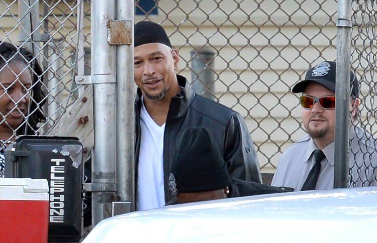 Former Carolina Panthers NFL football player Rae Carruth, center rear, exits the Sampson Correctional Institution in Clinton, N.C., Monday, Oct. 22, 2018. Carruth has been released from prison after serving 18 years for conspiring to murder the mother of his unborn child.  