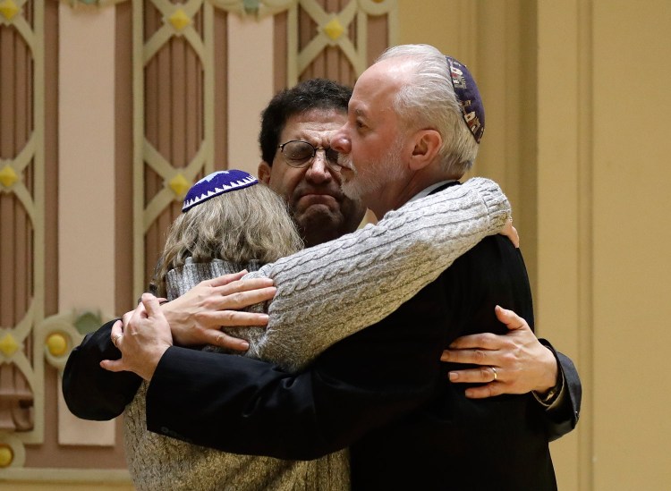 Rabbi Jeffrey Myers, right, of Tree of Life/Or L'Simcha Congregation hugs Rabbi Cheryl Klein, left, of Dor Hadash Congregation and Rabbi Jonathan Perlman during a community gathering held Sunday in the aftermath of the deadly shooting.