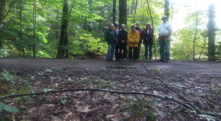 Walkers from the York County Senior College's ‘Out in the Woods II’ class, hosted by the Mousam Way Land Trust, stand at the end of Deering Pond where a railcar from 1871 went in. 