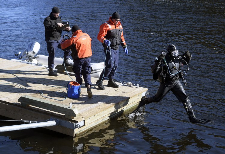 A diver from the Department of Public Safety's dive team leaps off a dock Friday on the Kennebec River in Richmond to search for Mark Johnston, who disappeared after leaving to move his boat from a mooring to the town dock.