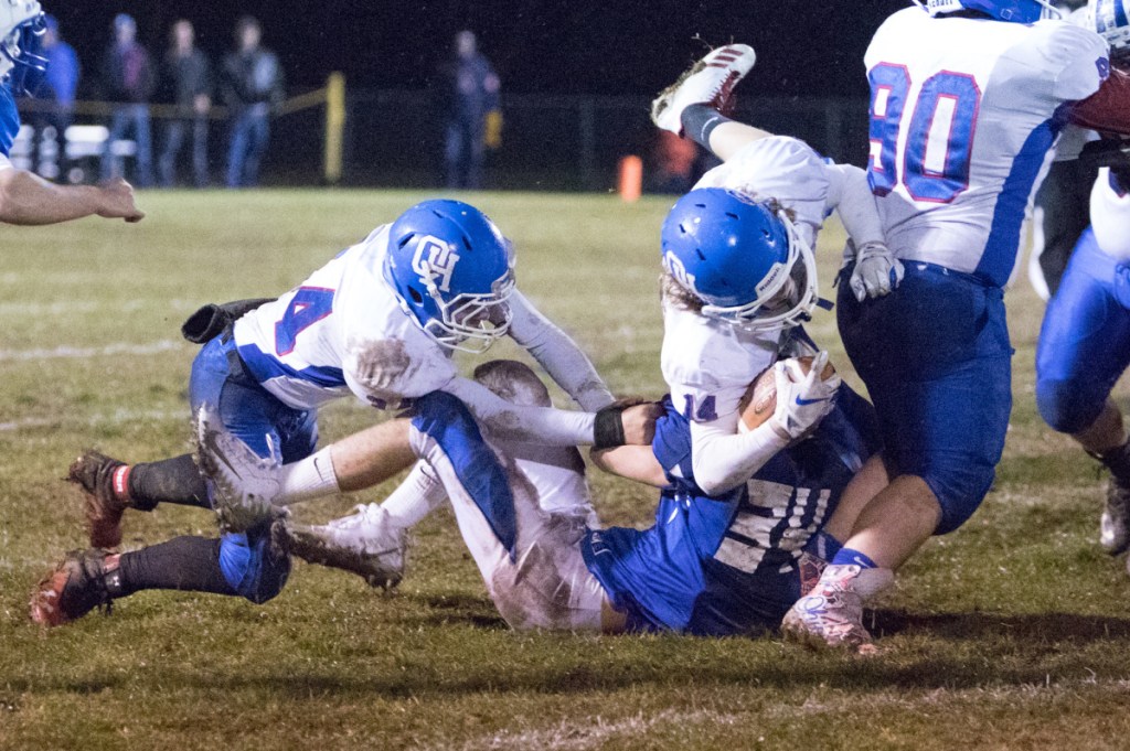 Oak Hill's Sam Lindsay carries the ball while being taken down by Madison's defense in a Class D South semifinal game Friday in Madison.