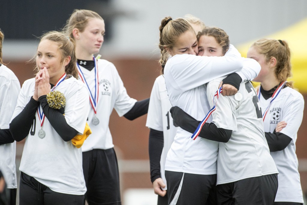 Members of the Maranacook girls soccer team console each other after a 1-0 loss to Fort Kent in the Class C girls state championship game Saturday at Hampden Academy.