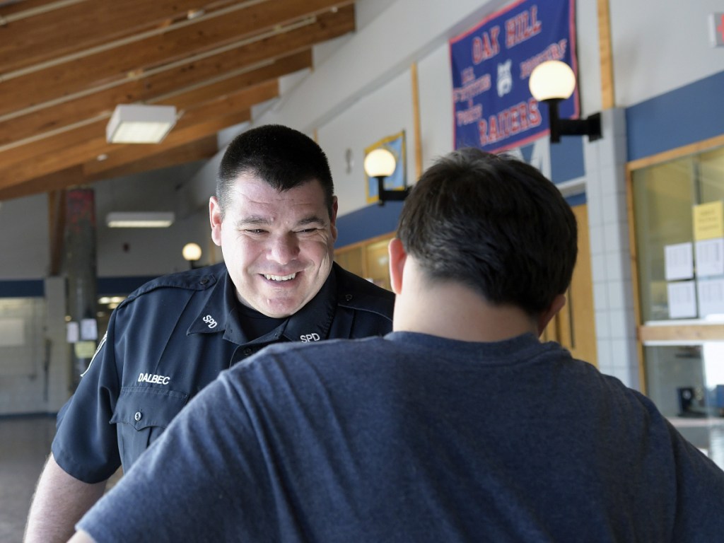 School resource officer John Dalbec confers with a buddy, Zachery Derosier, Oct. 10 in the lobby at Oak Hill High School in Wales. Dalbec said the best part of his job is speaking with students. Derosier is a junior.