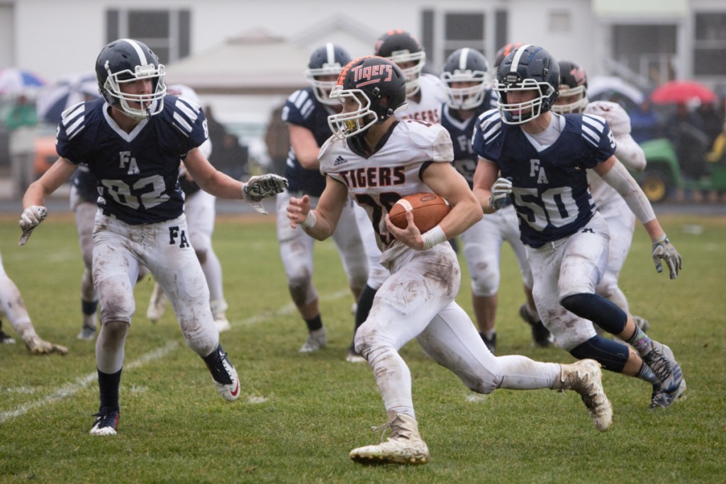 Gardiner's Garrett Maheux carries the ball past Fryeburg defenders Charlie Stokes (left) and Tucker Buzzell (right) in a Class C South semifinal game Saturday at Fryeburg Acedemy.
