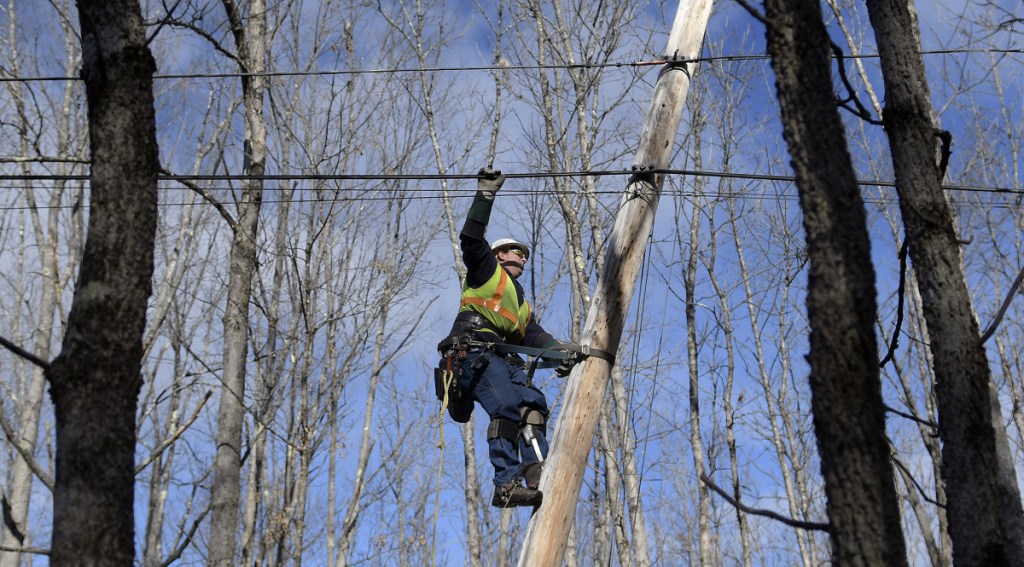 Central Maine Power lineman Sam Pottle scales a utility pole Sunday in Readfield. Pottle and his partner, George Marston, restored power at several locations in Kennebec County after wind knocked out service to 38,000 customers.