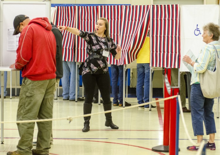 Deputy warden Kim Ward points voters to an open booth around 8:10 a.m. Tuesday at the Boys and Girls Clubs of Kennebec Valley in Gardiner. There were long lines just after the doors opened.