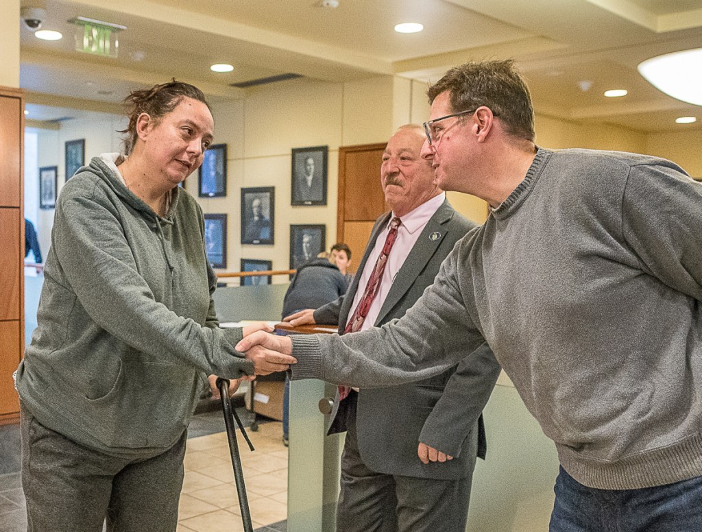 Amy Osborne is greeted by District Attorney Andrew Robinson, far right, early Tuesday morning at Auburn City Hall. Rep. Bruce Bickford, center, also was greeting voters.