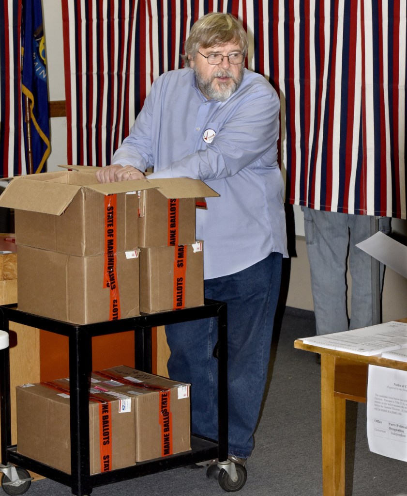 Staff photo by David Leaming
Skowhegan election warden David James keeps his hand on boxes of official state ballots during voting Tuesday at the Skowhegan Municipal Building. "We're using a lot of these," James said, referring to ballots and citing a steady turnout of voters.