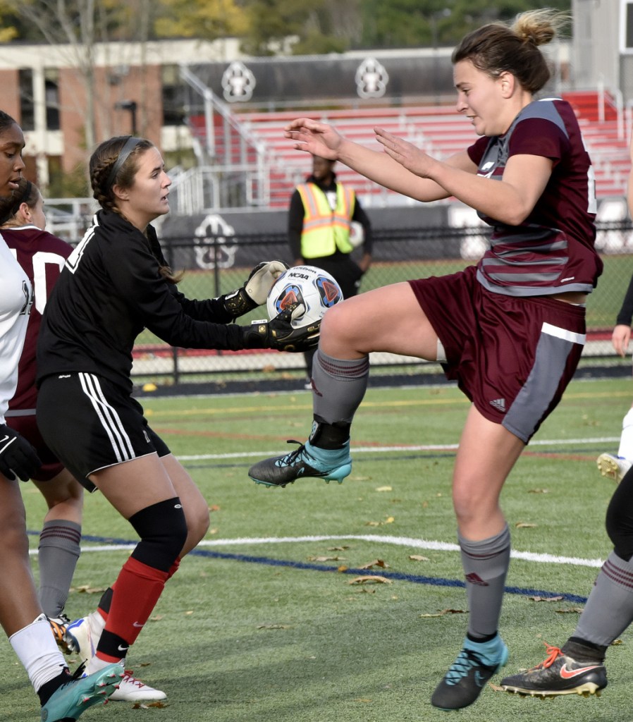 Thomas keeper Kayla Gordon, left, makes a safe as UMF's Hadley Yescott pressures her in the North Atlantic Conference championship game Sunday in Waterville.