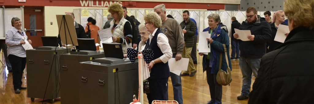 Oakland Town Clerk Jan Porter, center, assists a steady flow of voters Tuesday at the Williams School.