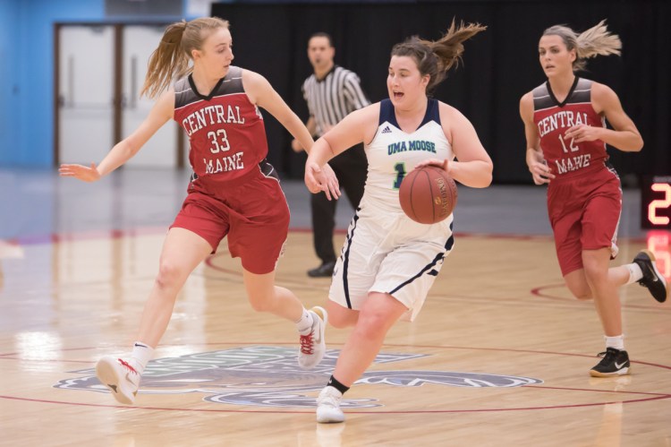 University of Maine at Augusta's Catherine Sanborn, middle, pushes the ball down the court while Central Maine Community College defender Ahna McCusker tries to keep pace during a game Tuesday night at the Augusta Civic Center.