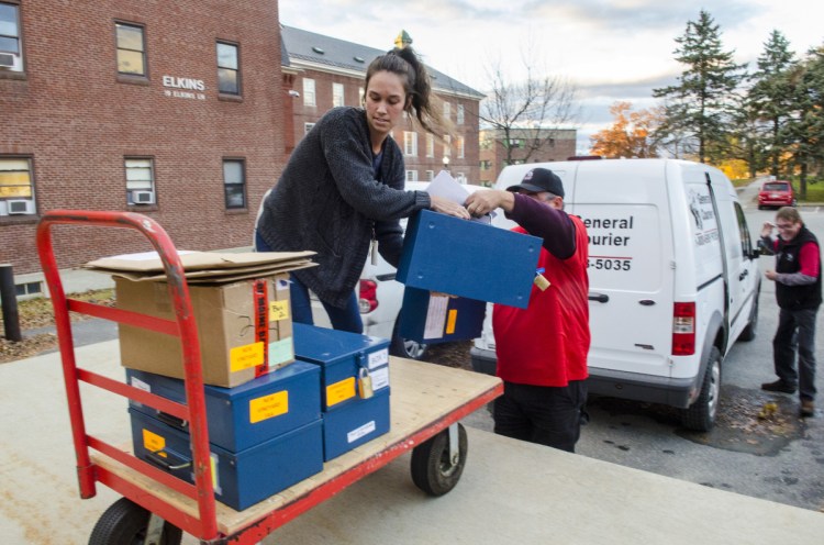 Secretary of State's Office employees and courier service drivers take ballots out of vans and into the Elkins Building in Augusta on Thursday. The ranked-choice vote count is expected begin there Friday.