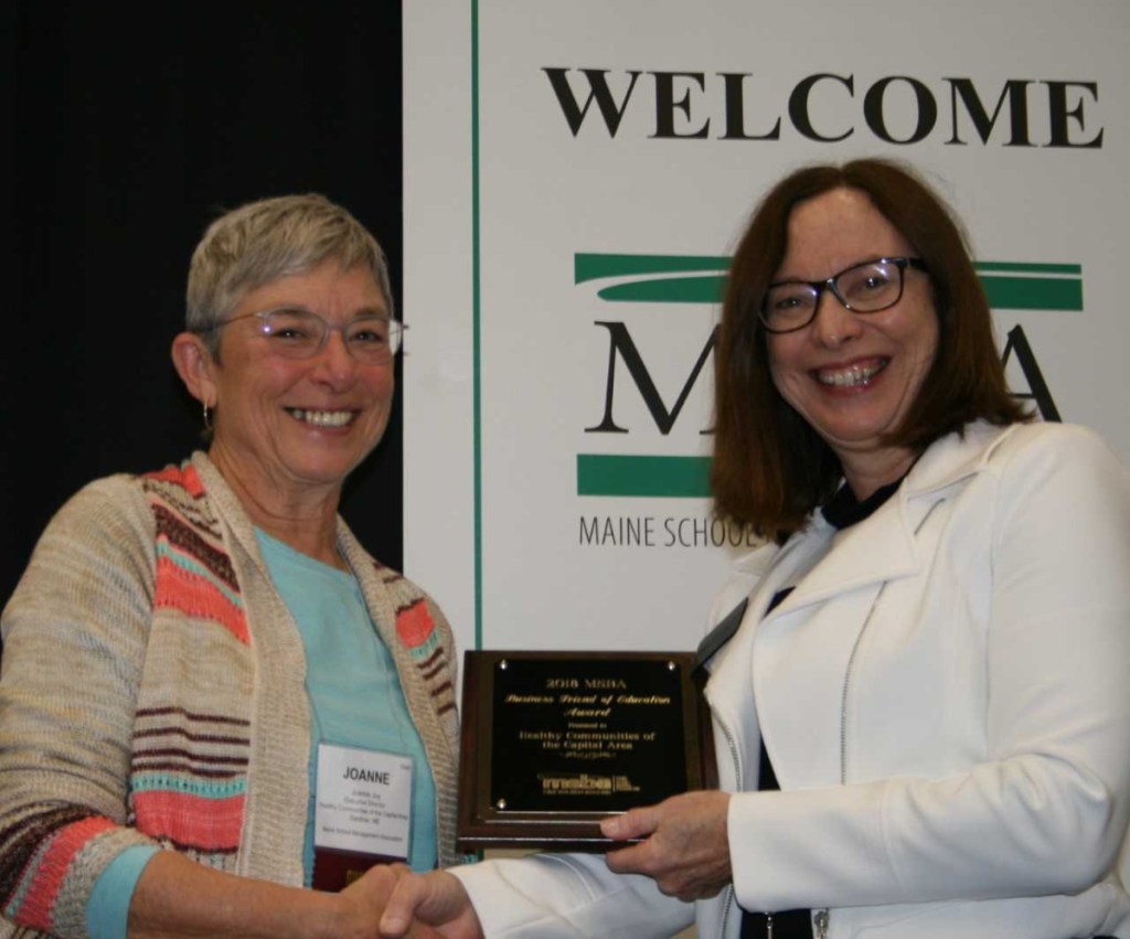 Healthy Communities Executive Director Joanne Joy, left, accepts the Maine School Boards Association Business Friend of Education Award from MSBA President Maureen King.