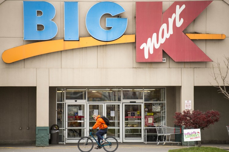 A shopper rides by the Kmart store Friday at Elm Plaza on Main Street in Waterville.