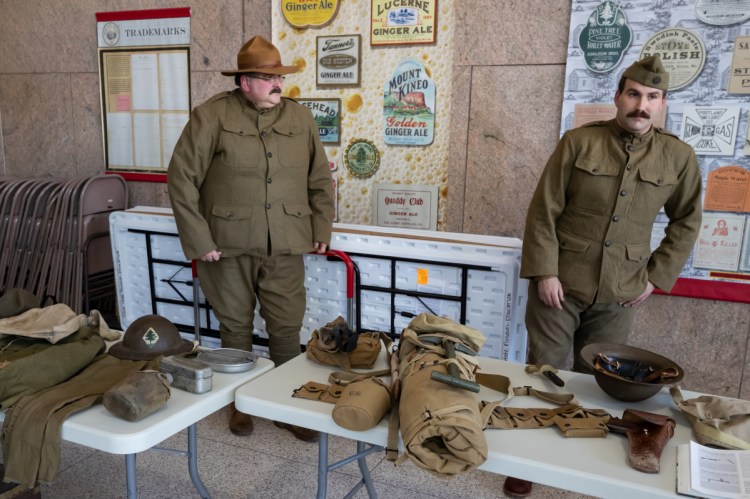 Dave Backus, of Waldoboro, left, and his son, Tom Backus, of Warren, right, stand in period uniform to display items that American Soldiers carried during World War One in Augusta on Sunday. Armistice Day Centennial Celebration, starting at the 11th hour on the 11th day of the 11th month of the year was to mark the 100th year anniversary of the armistice signed between Germany and the Allies which officially ended The Great War.