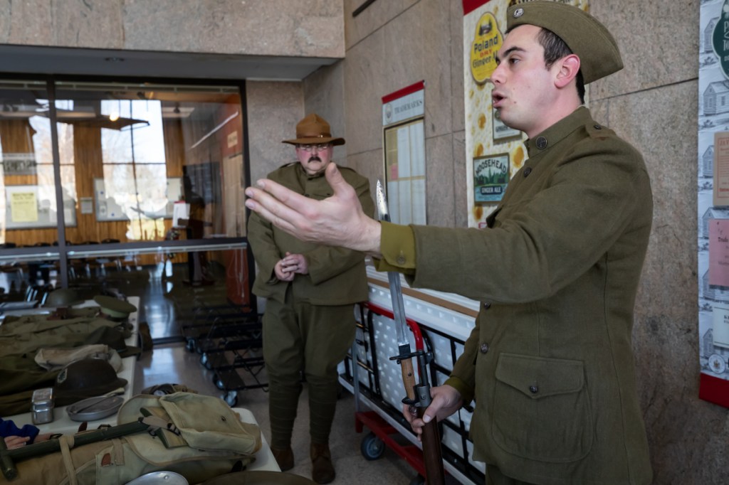 Tucker Goodwin, of Boothbay Harbor, foreground, talks about the length of the bayonet attached to the service rifle during the Armistice Day Centennial Celebration at the Maine State Cultural Building in Augusta on Sunday. The event brought actors dressed in period uniforms as well as extended hours to the museum's exhibit "Over there and down home: Mainers and World War I." This enabled visitors to see century old artifacts on Veterans Day.