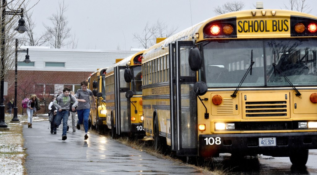 Messalonskee Middle School students run on Tuesday to a line of buses parked outside the school in Oakland. A grant resulting from a Volkswagen settlement with the U.S. government will help pay for two propane-fueled buses that RSU 18 plans to acquire.