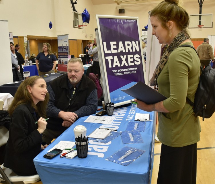Cristine Aston, left, and Don Hart, of Jackson Hewitt Tax Service, answer questions Thursday from Karina Beadling during a job fair held at Kennebec Valley Community College's Hinckley campus.