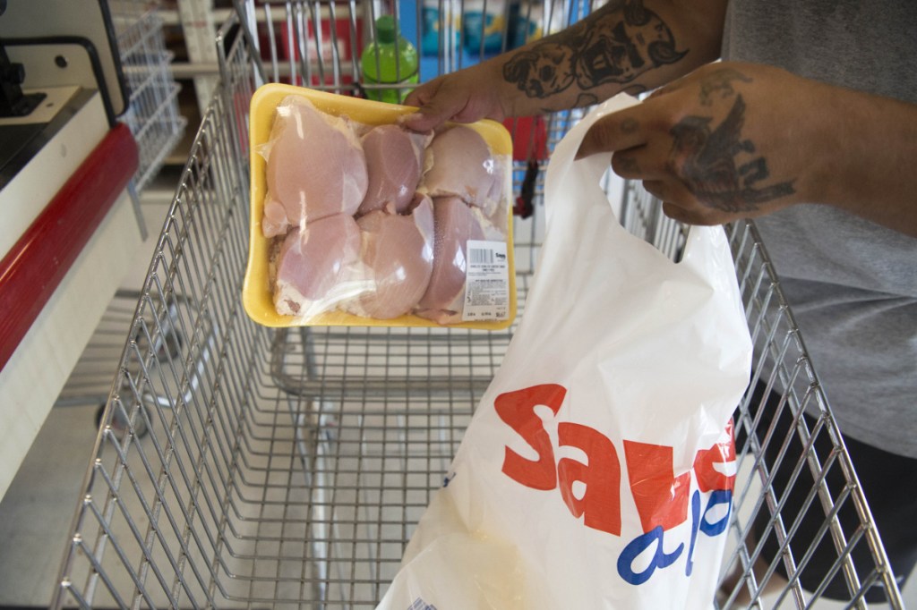Greg Oullette bags his own groceries with a plastic bag Aug. 15 after shopping at Save-A-Lot in Waterville.