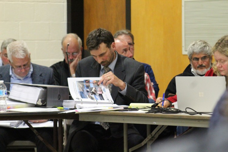 Attorney David Kallin, center, reviews evidence at Thursday night's public hearing on a proposed expansion of Mere Point Oyster Co.'s cultivation operation in Brunswick. Kallin is representing the Maquoit Bay Preservation Group, or the Concerned Citizens of Maquoit Bay.