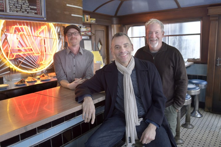 After three decades, Michael Giberson, right, and Neil Andersen, center, are handing the reins of the A1 Diner in Gardiner over to Aaron Harris. The men gathered at the renowned eatery on Monday.