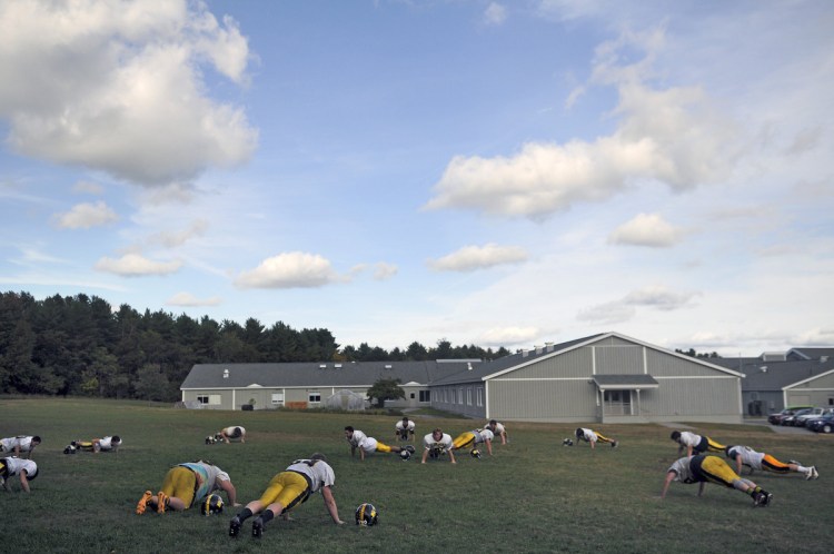The Maranacook Community High School football squad does sit-ups in 2016 during practice at the Readfield school.