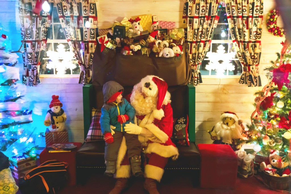 Emberly Furbush, 4, of Winslow, meets Santa Claus on Friday evening at Kringleville in Castonguay Square as part of the Waterville Parade of Lights.