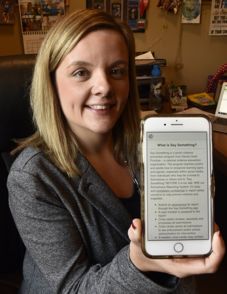 Beth Carlton, student services coordinator at Mid-Maine Technical Center in Waterville, on Nov. 15, holds a cellphone with the "Say Something" app installed. Students will be offered the app to be used to notify officials if they hear or read inappropriate threats or comments.