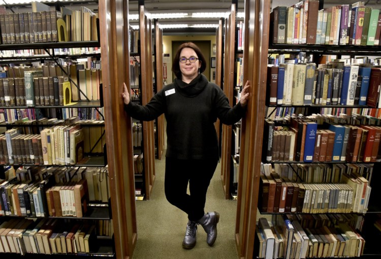 Tammy Rabideau, the new director of the Waterville Public Library, in the main stack section of the library on Wednesday. The new director hopes to increasingly bring the Waterville and Colby communities together, choosing to refer to the area as one "community with a capital C."