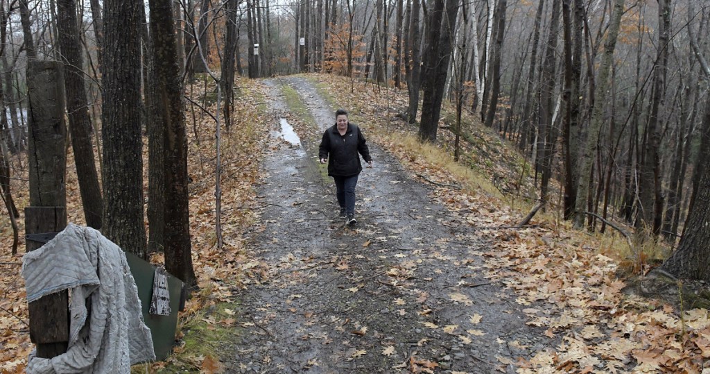 Monique Poulin walks to her home on Nov. 13, down the road that abuts Boothby Street, from the pits located at the Augusta Public Works facility.