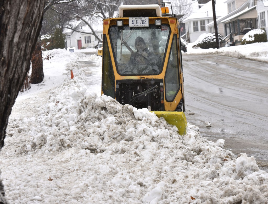 Todd Mathieu of the Waterville Public Works department clears snow from sidewalks in Waterville during a snowstorm on Tuesday.
